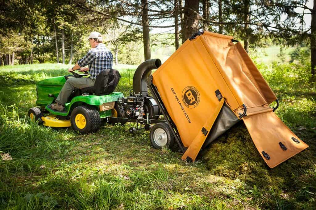 Man using his lawn mower then towing grass sweeper