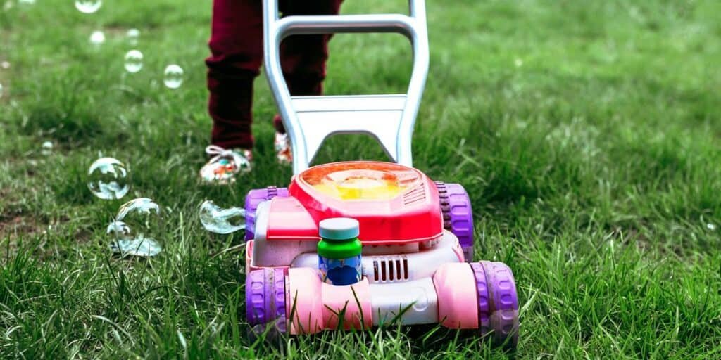 baby riding his lawn mower toy